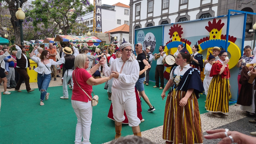 Turistas cantam e bailam na placa central. Espreite o vídeo.